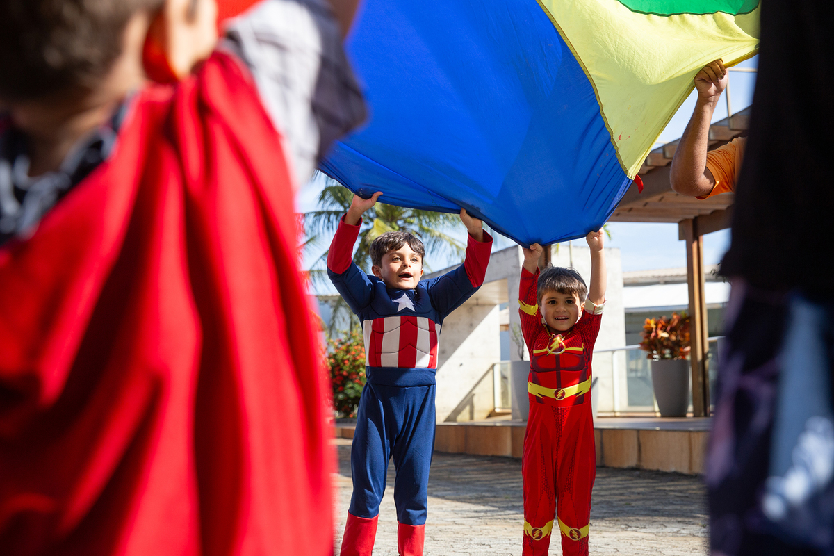 Momento de brincadeira entre crianças em festa infantil dos super heróis