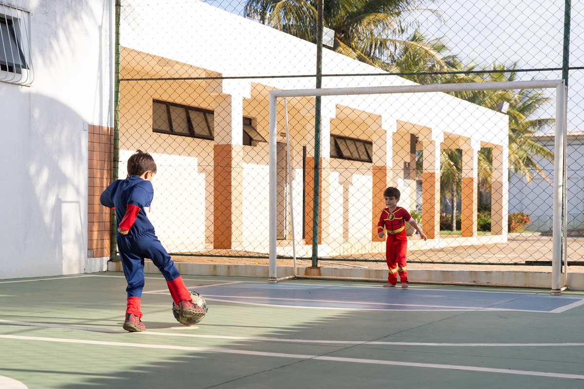 Momento de brincadeira entre crianças em festa infantil dos super heróis