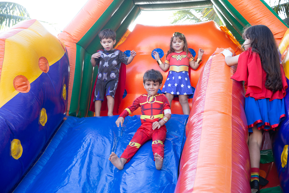 Momento de brincadeira entre crianças em festa infantil dos super heróis