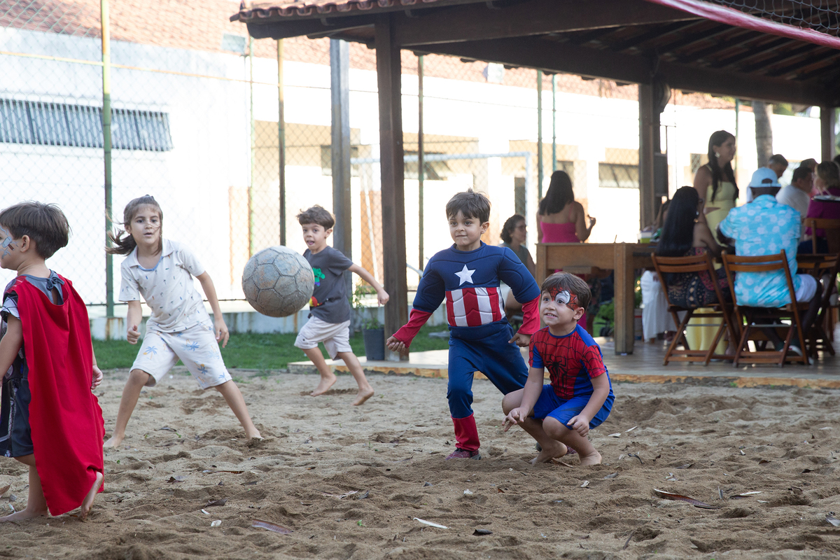 Momento de brincadeira entre crianças em festa infantil dos super heróis