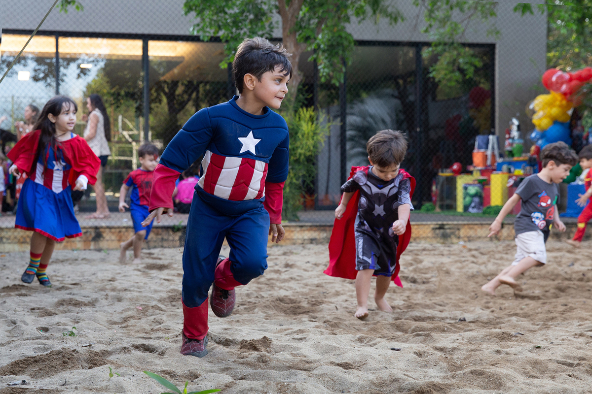 Momento de brincadeira entre crianças em festa infantil dos super heróis
