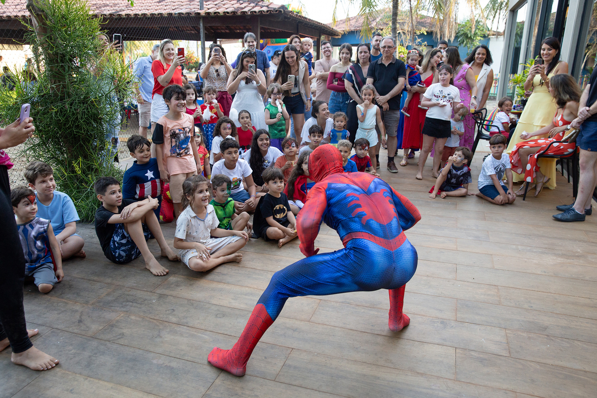 Momento de brincadeira entre crianças e o Homem-Aranha em festa infantil dos super heróis
