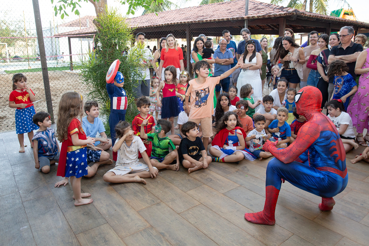 Momento de brincadeira entre crianças e o Homem-Aranha em festa infantil dos super heróis