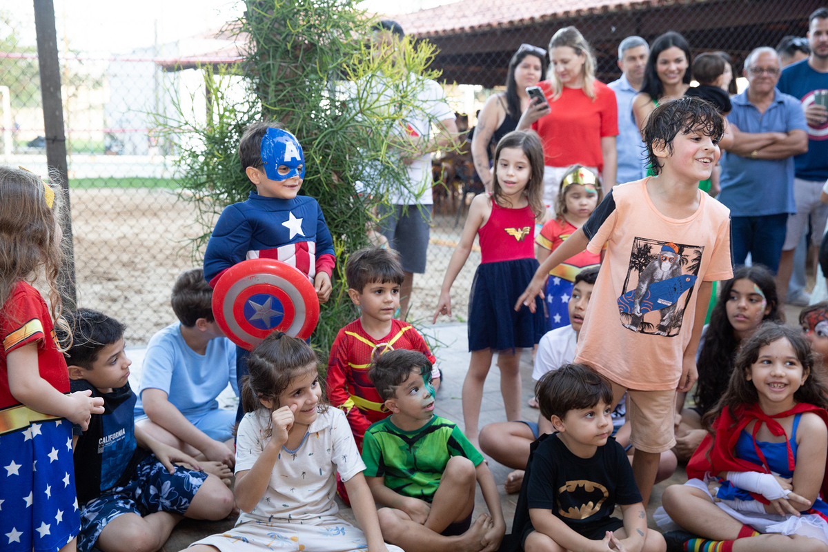Momento de brincadeira entre crianças e o Homem-Aranha em festa infantil dos super heróis