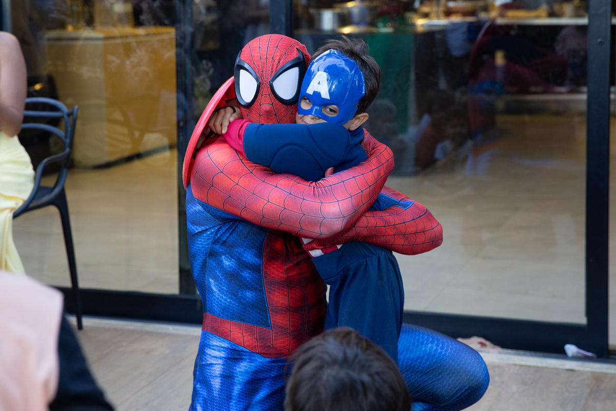 Momento de brincadeira entre crianças e o Homem-Aranha em festa infantil dos super heróis