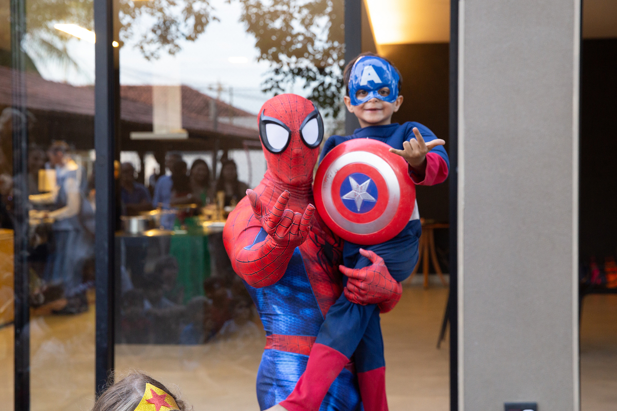 Momento de brincadeira entre crianças e o Homem-Aranha em festa infantil dos super heróis