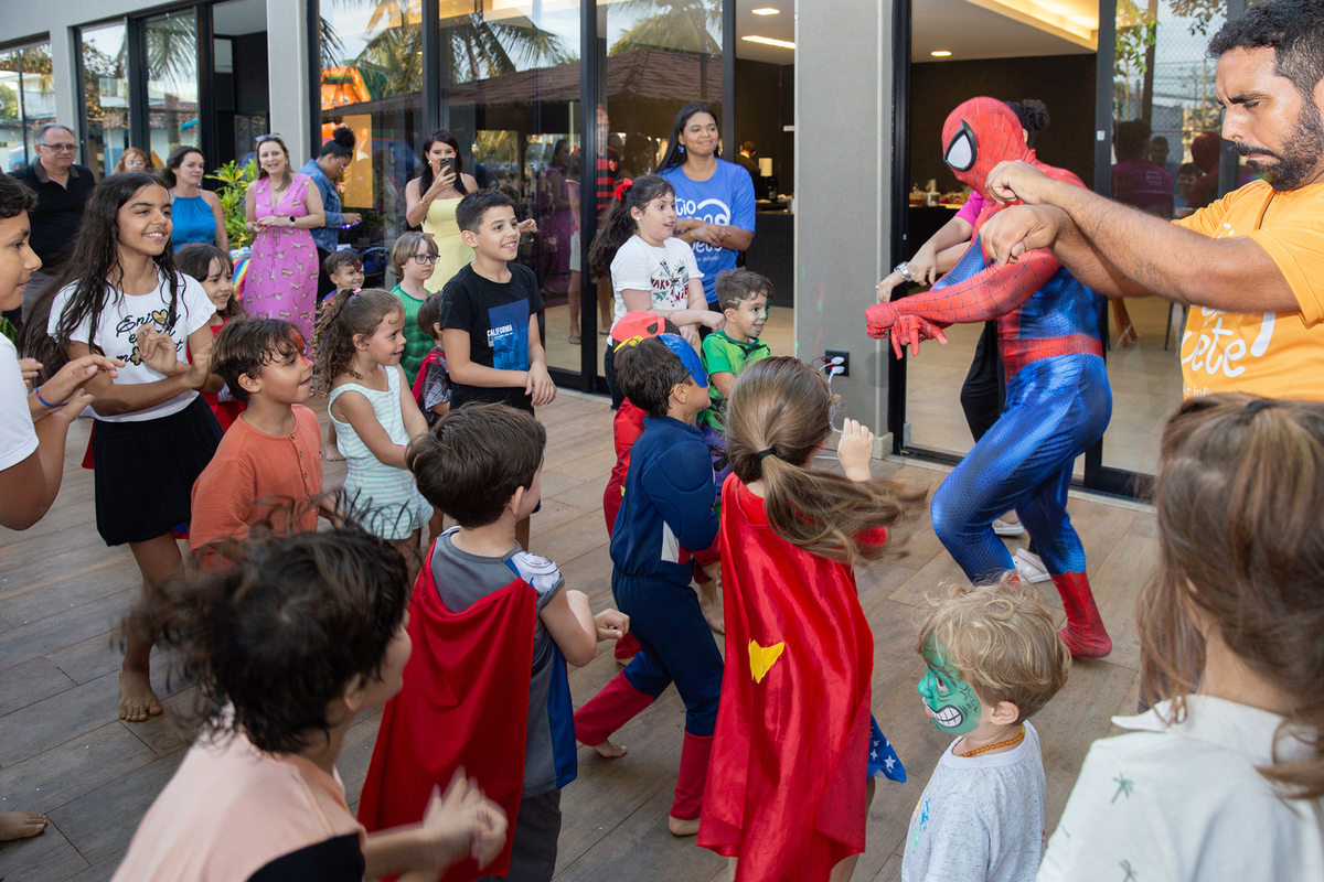 Momento de brincadeira entre crianças e o Homem-Aranha em festa infantil dos super heróis