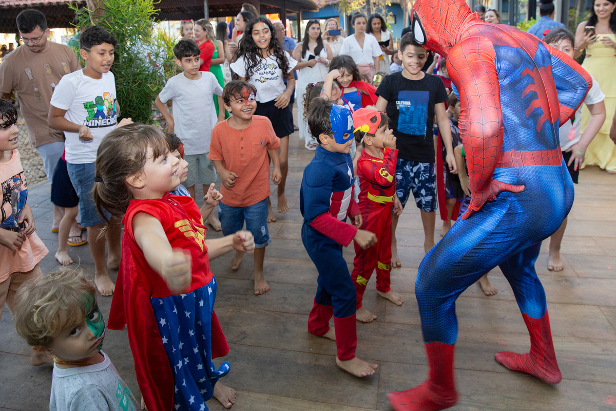 Momento de brincadeira entre crianças e o Homem-Aranha em festa infantil dos super heróis