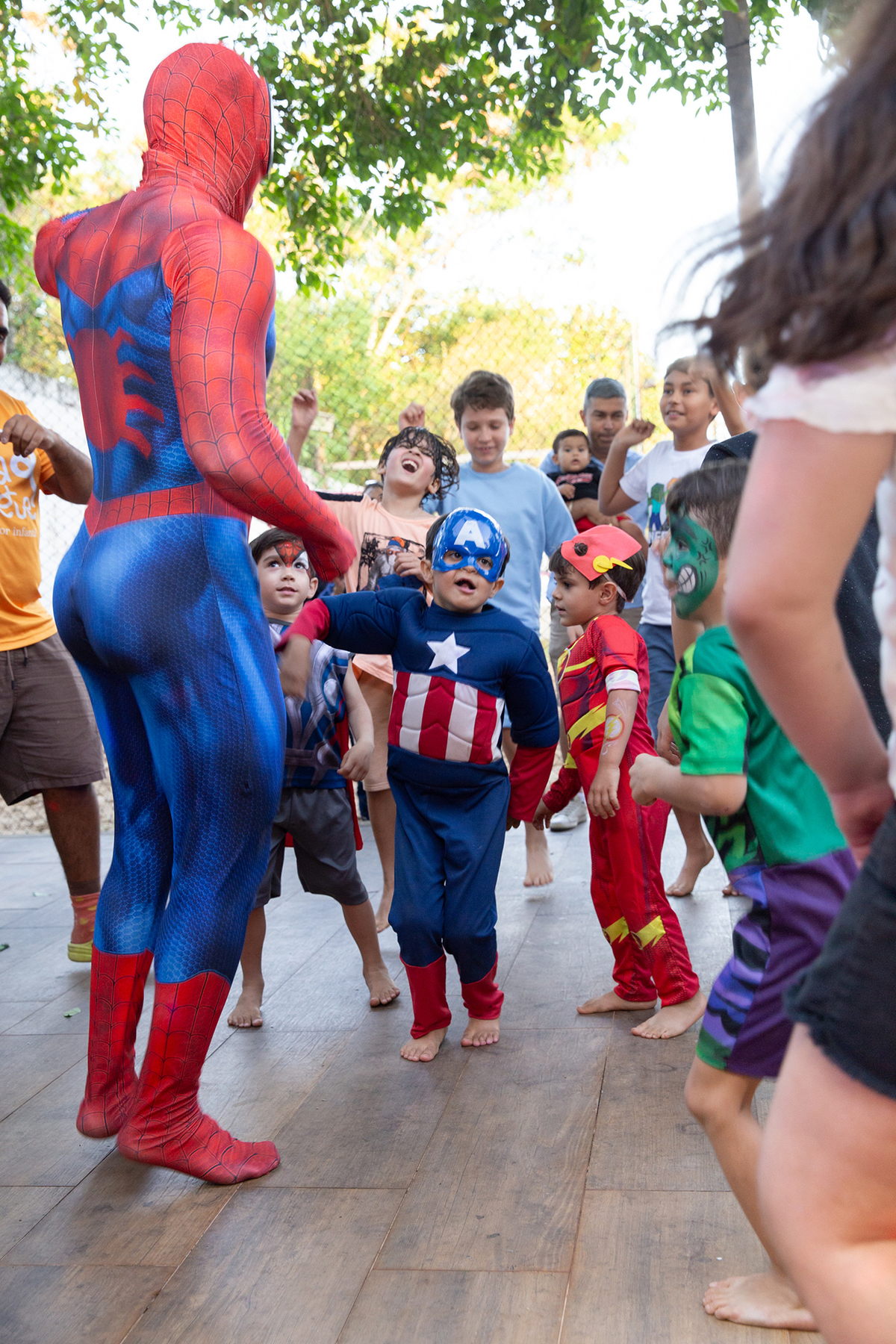 Momento de brincadeira entre crianças e o Homem-Aranha em festa infantil dos super heróis