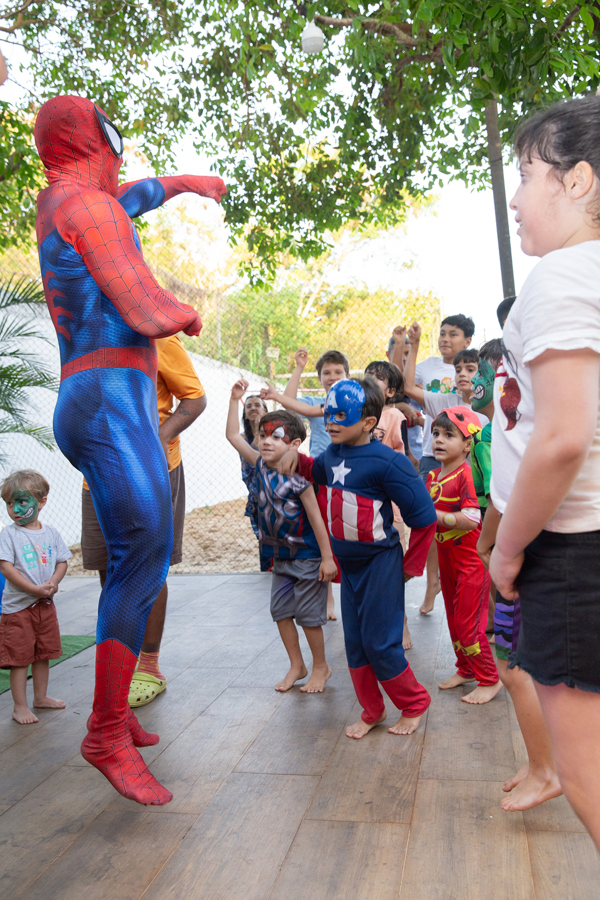 Momento de brincadeira entre crianças e o Homem-Aranha em festa infantil dos super heróis