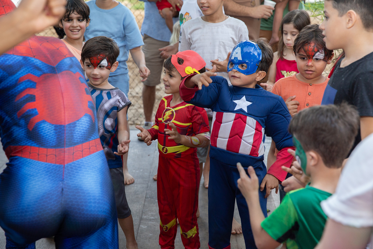 Momento de brincadeira entre crianças e o Homem-Aranha em festa infantil dos super heróis