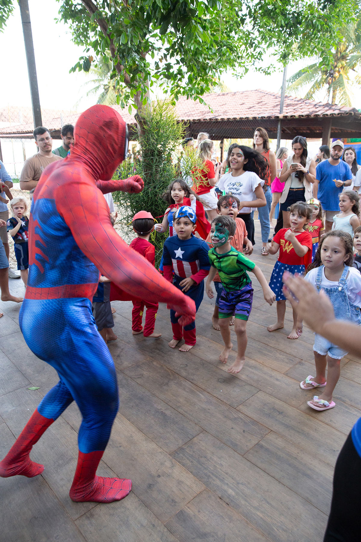 Momento de brincadeira entre crianças e o Homem-Aranha em festa infantil dos super heróis
