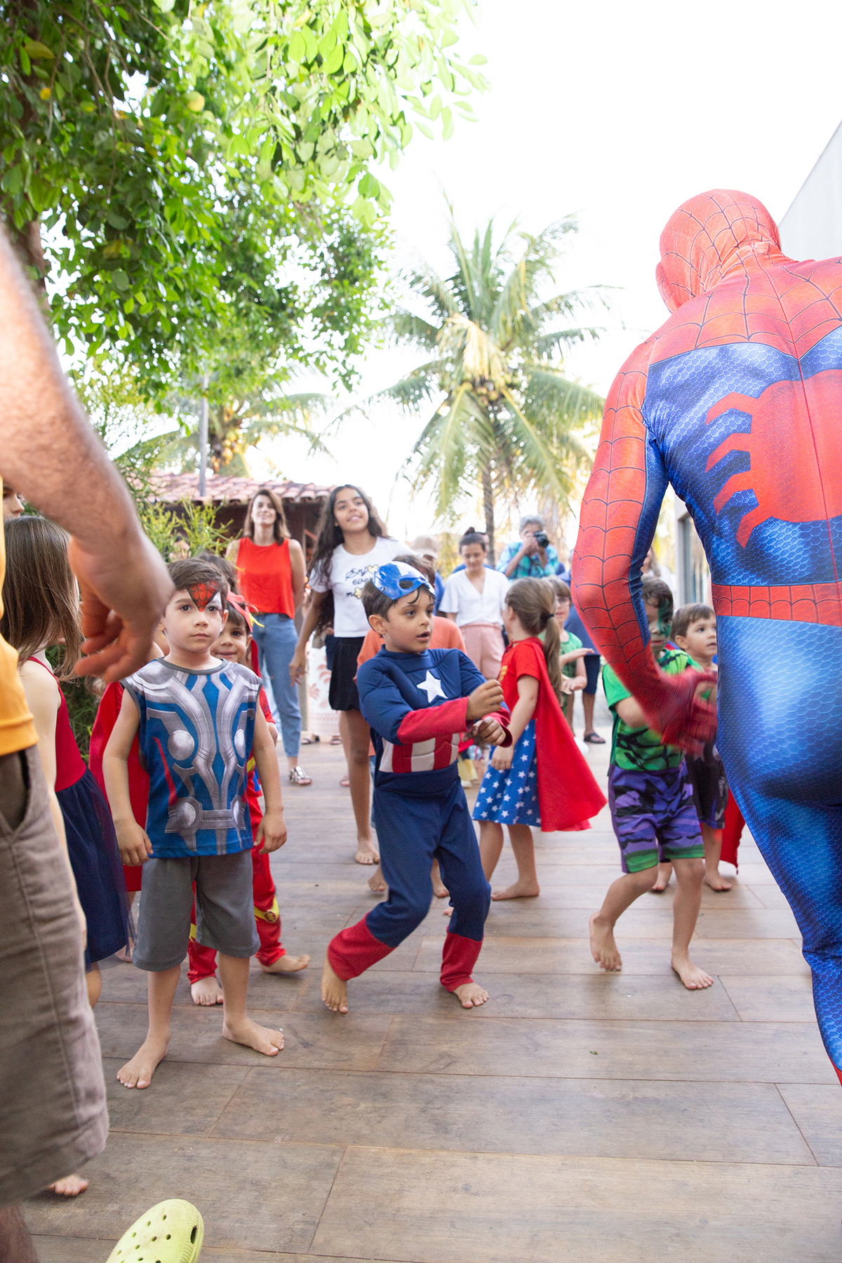 Momento de brincadeira entre crianças e o Homem-Aranha em festa infantil dos super heróis