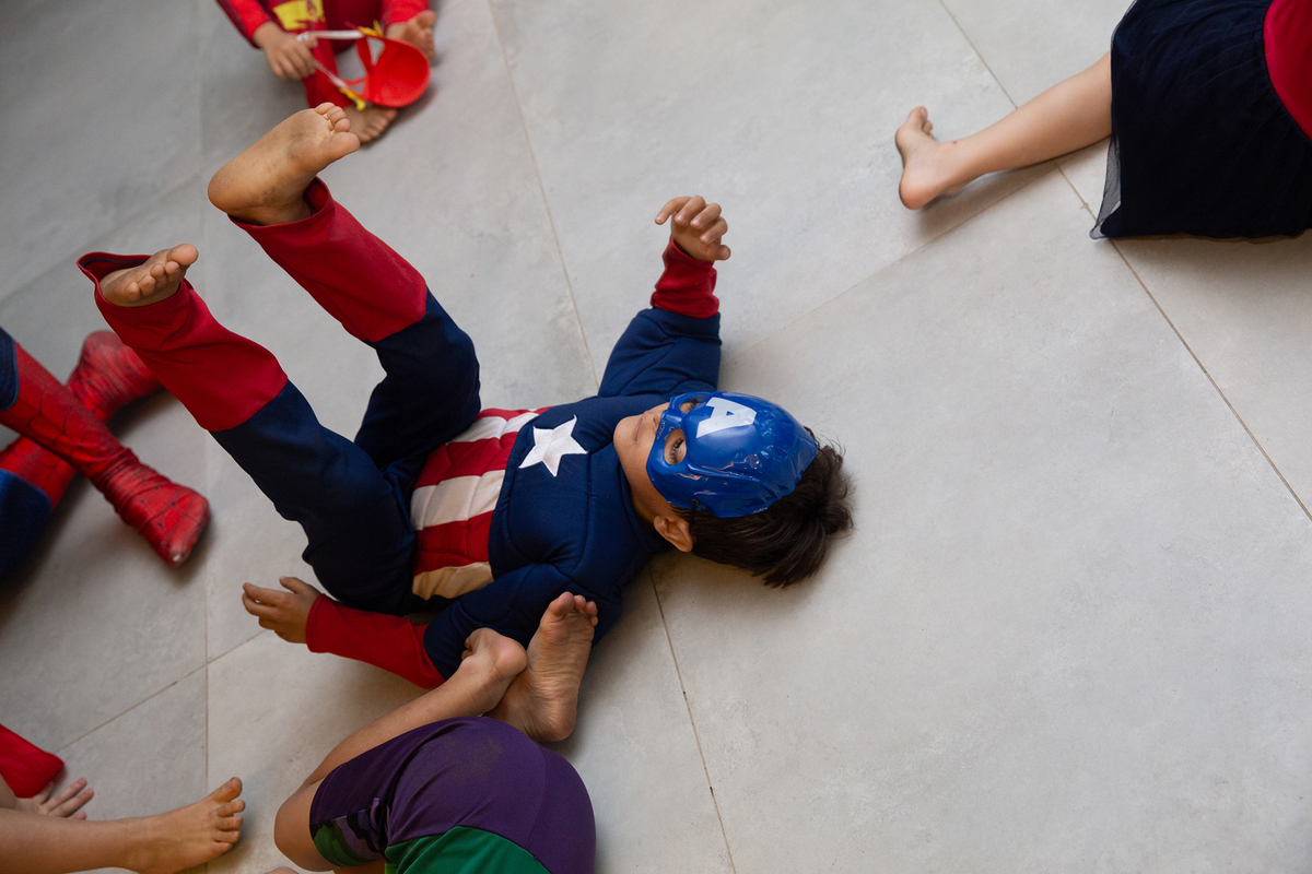 Momento de brincadeira entre crianças e o Homem-Aranha em festa infantil dos super heróis