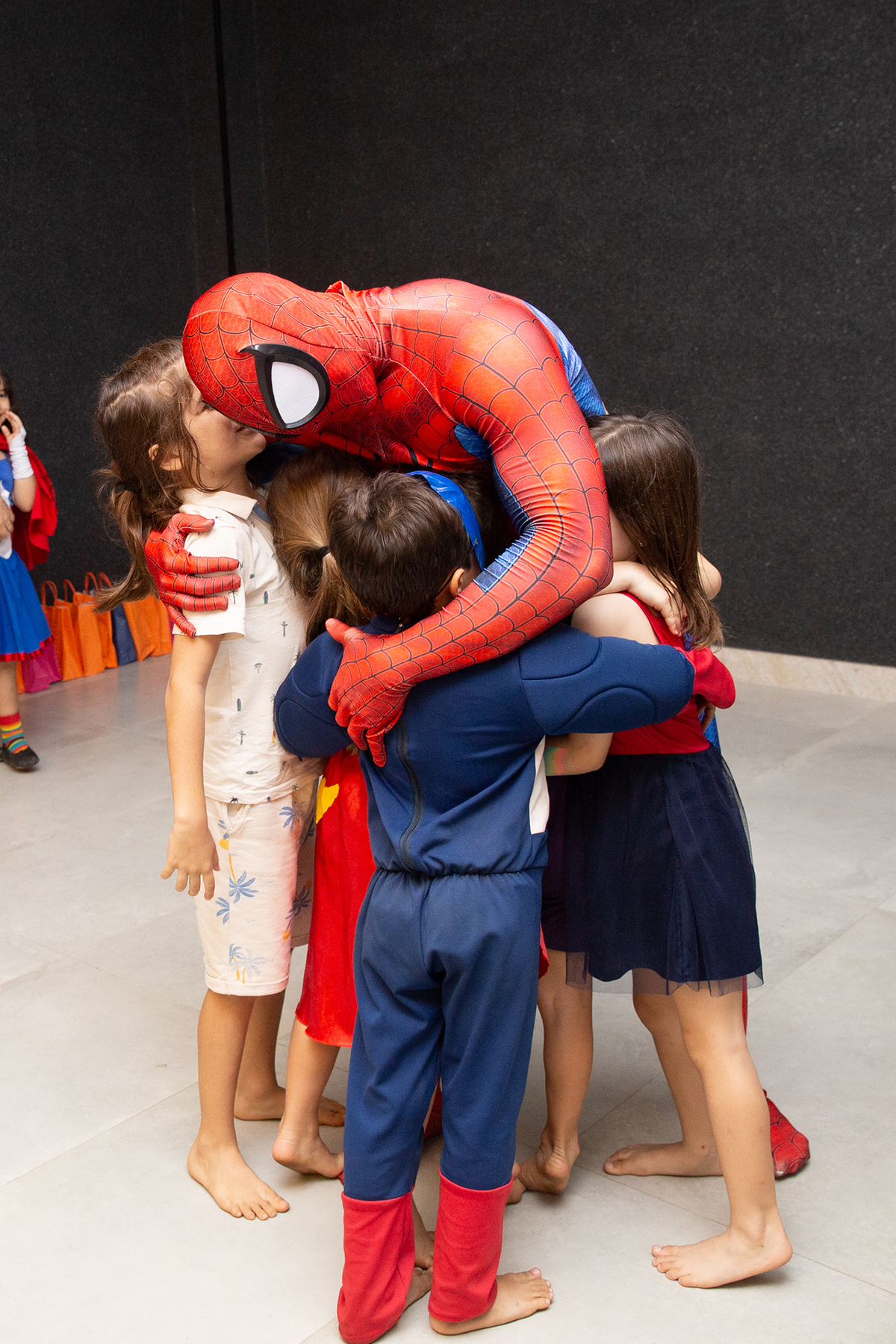 Momento de brincadeira entre crianças e o Homem-Aranha em festa infantil dos super heróis