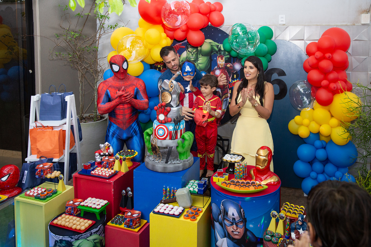 Família reunida com Homem-Aranha, na mesa de bolo para cantar os parabéns 
