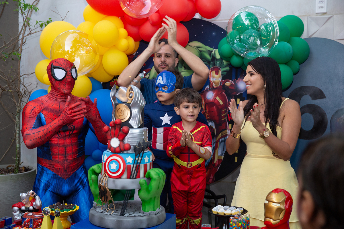 Família reunida com Homem-Aranha, na mesa de bolo para cantar os parabéns 