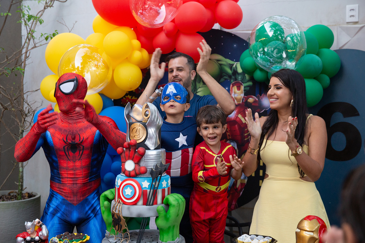 Família reunida com Homem-Aranha, na mesa de bolo para cantar os parabéns 
