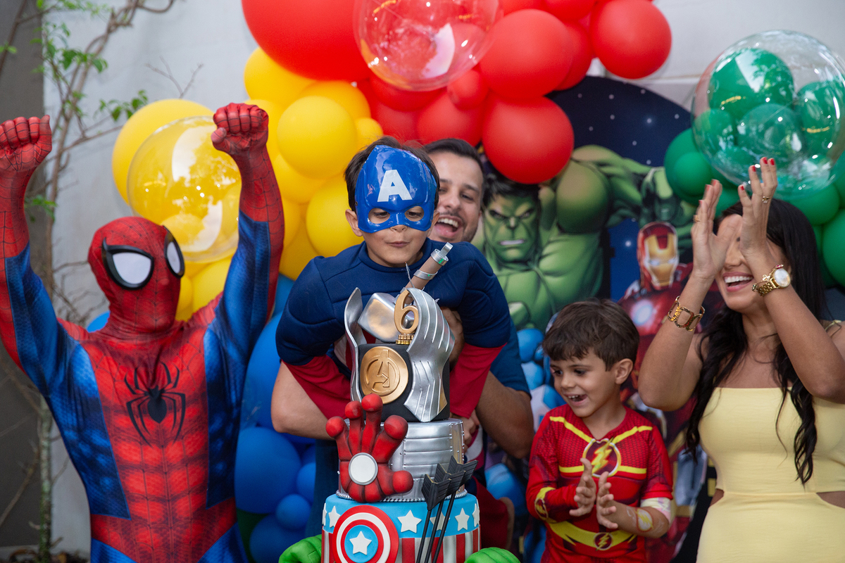 Família reunida com Homem-Aranha, na mesa de bolo para cantar os parabéns 
