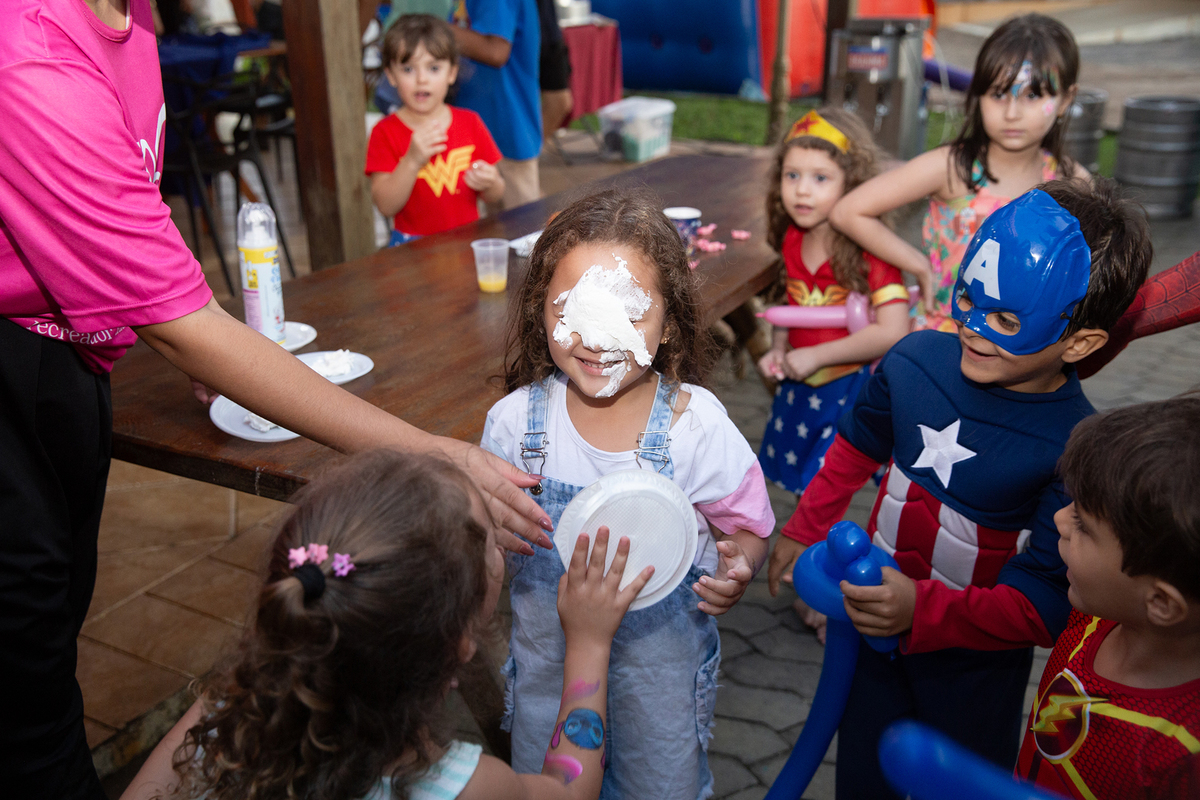 Momento de brincadeira entre crianças em festa infantil dos super heróis