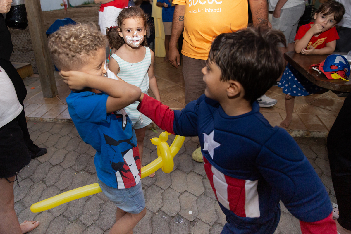 Momento de brincadeira entre crianças em festa infantil dos super heróis