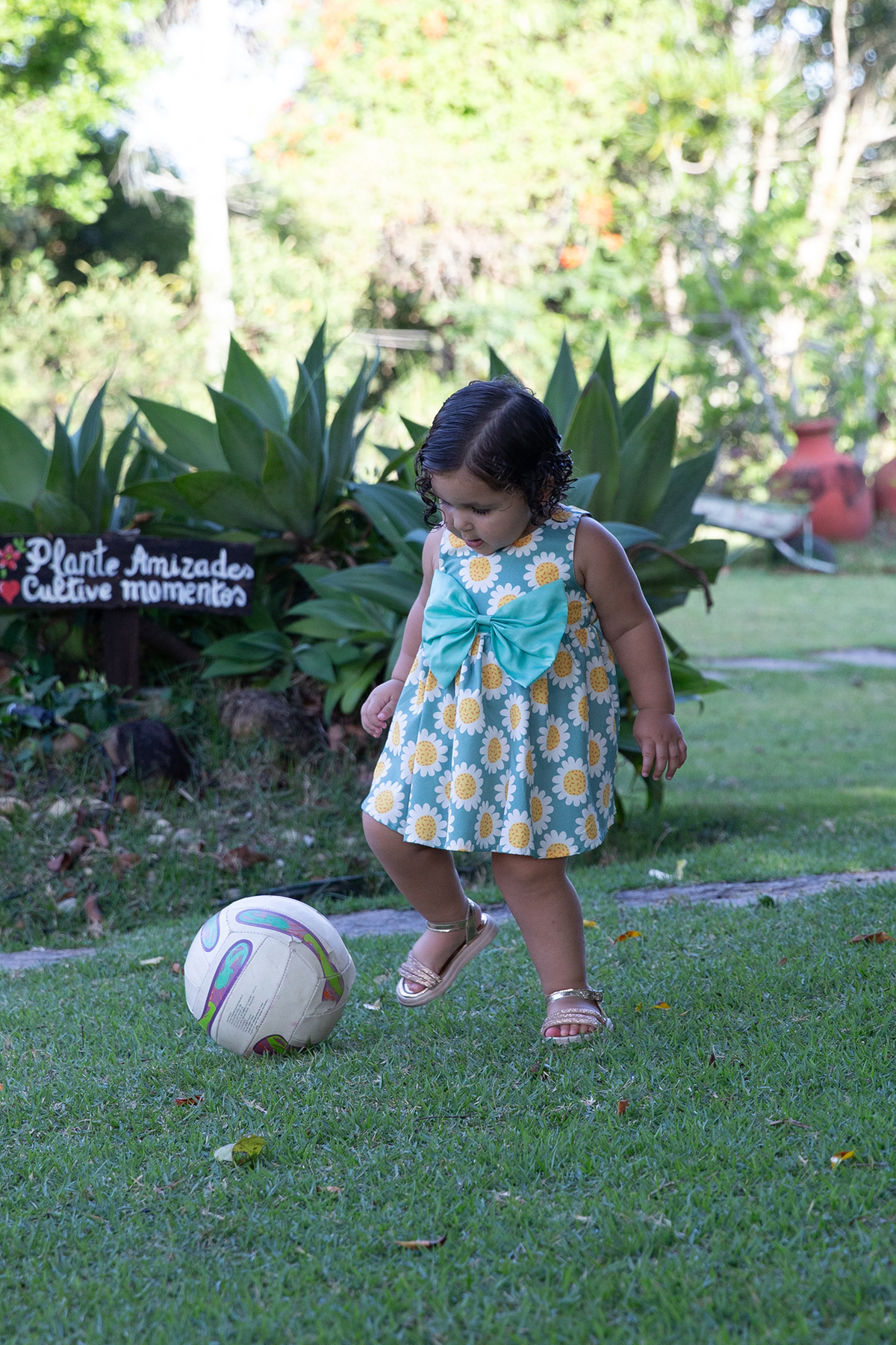criança brincando de bola no jardim 