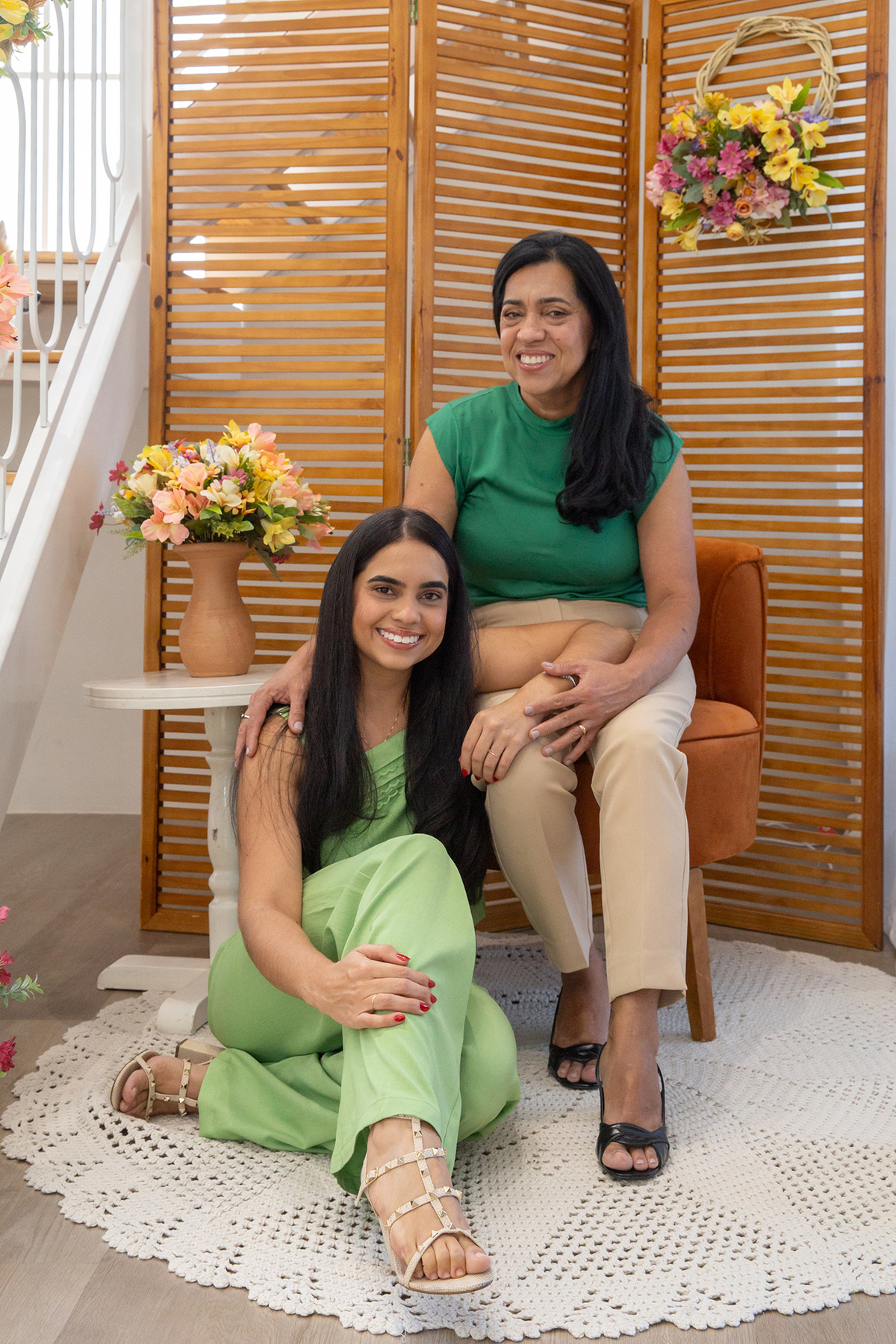 Mae e filha posando para foto juntas no cenário flores de dia das mães