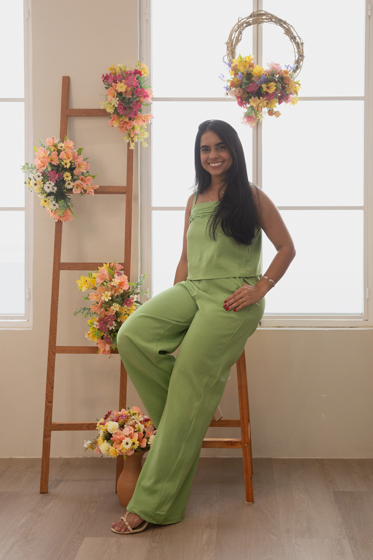 Mae de pet, no cenário de flores,  fotografada em um ângulo mais aberto, de corpo inteiro