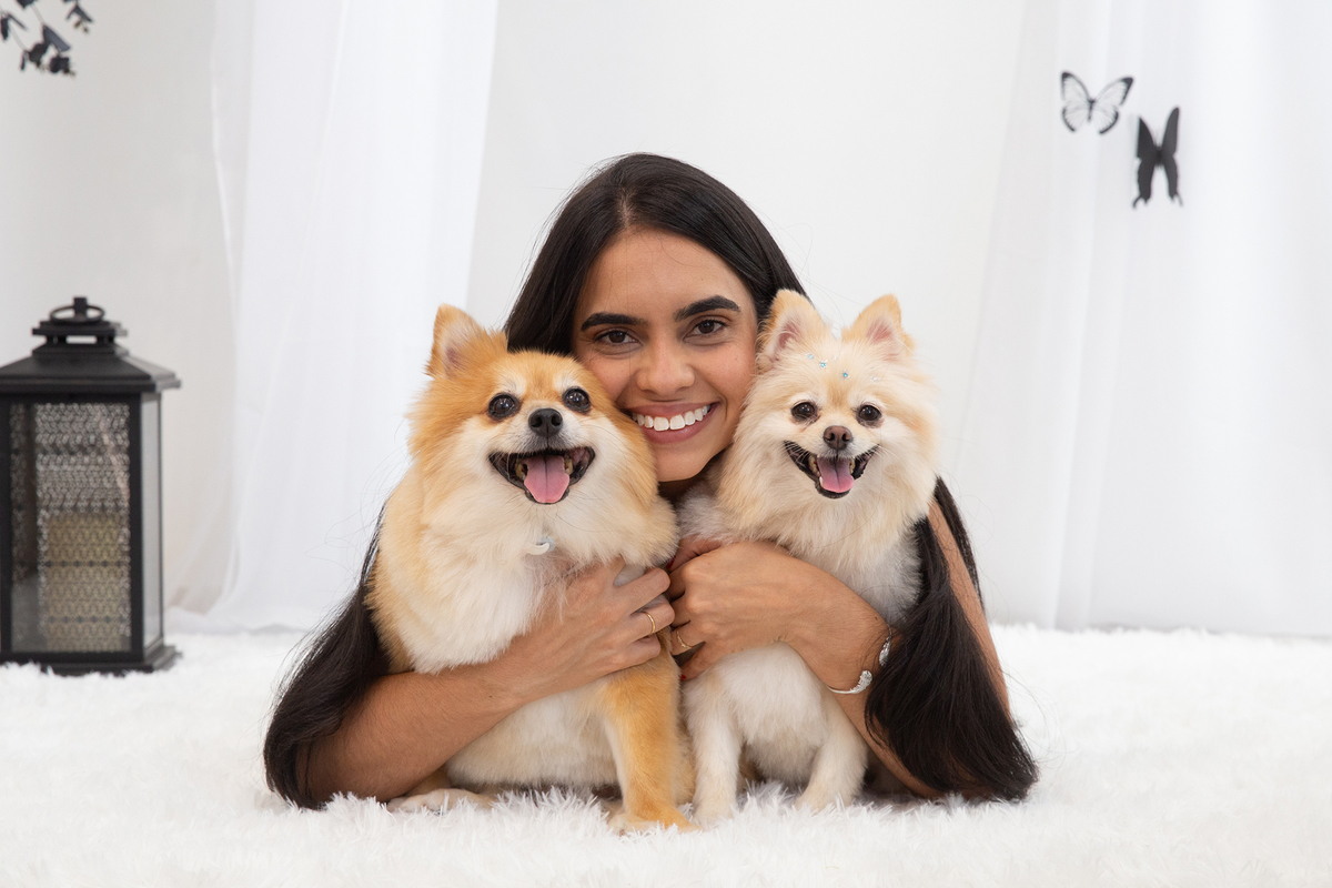 Mãe de pet interagindo com seus spitz, todos sorridentes, no cenário borboletas preto e branco 
