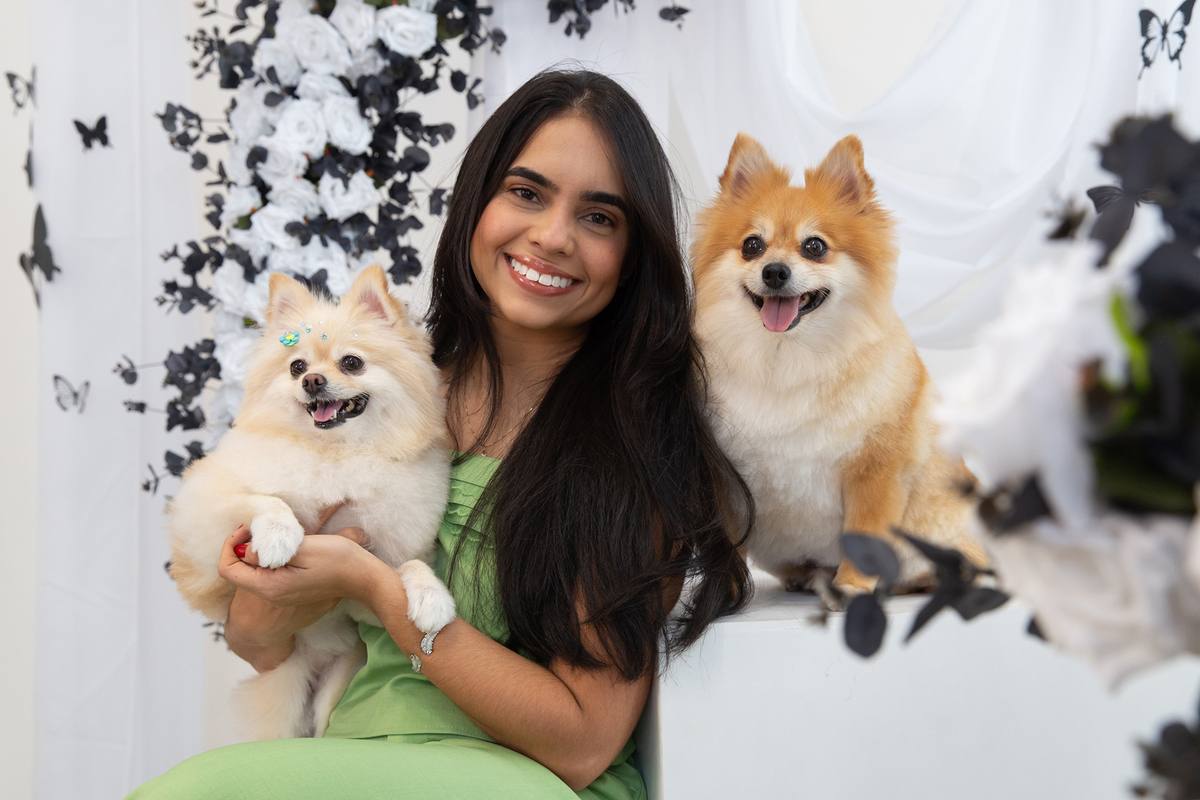 Mãe de pet interagindo com seus spitz, todos sorridentes, no cenário borboletas preto e branco 