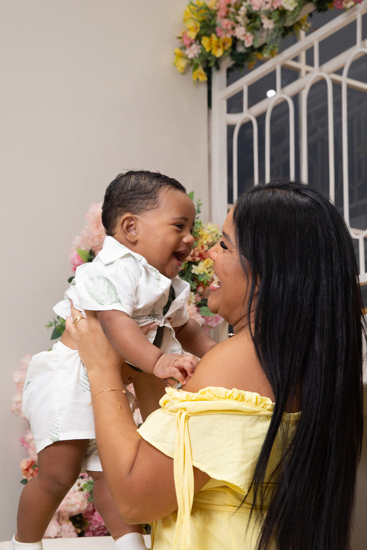 mãe e filho interagindo, brincando no cenário de dia das mães Flores, os dois sorrindo