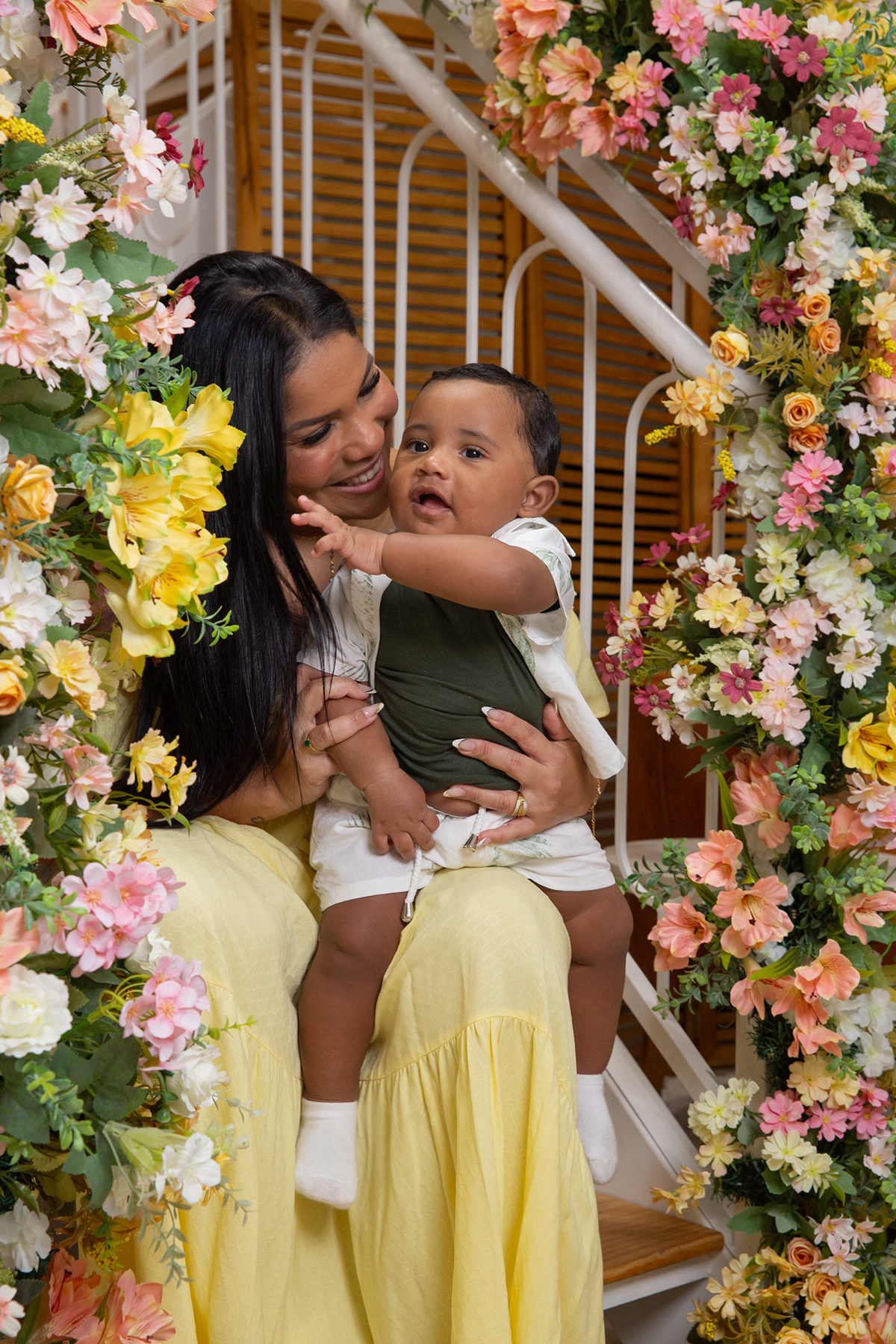 mãe e filho interagindo, brincando no cenário de dia das mães Flores, os dois sorrindo