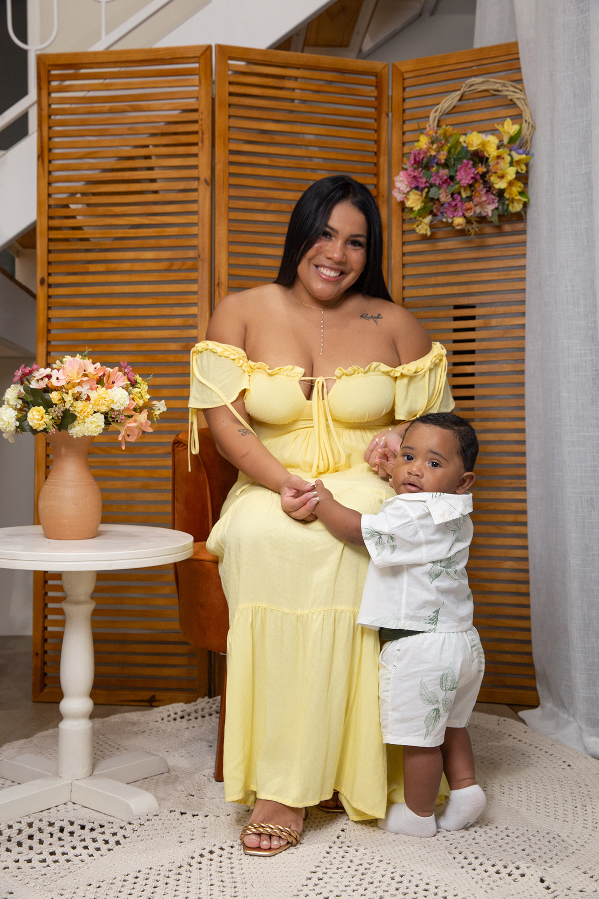 mãe e filho posando para câmera, no cenário de dia das mães Flores, os dois sorrindo