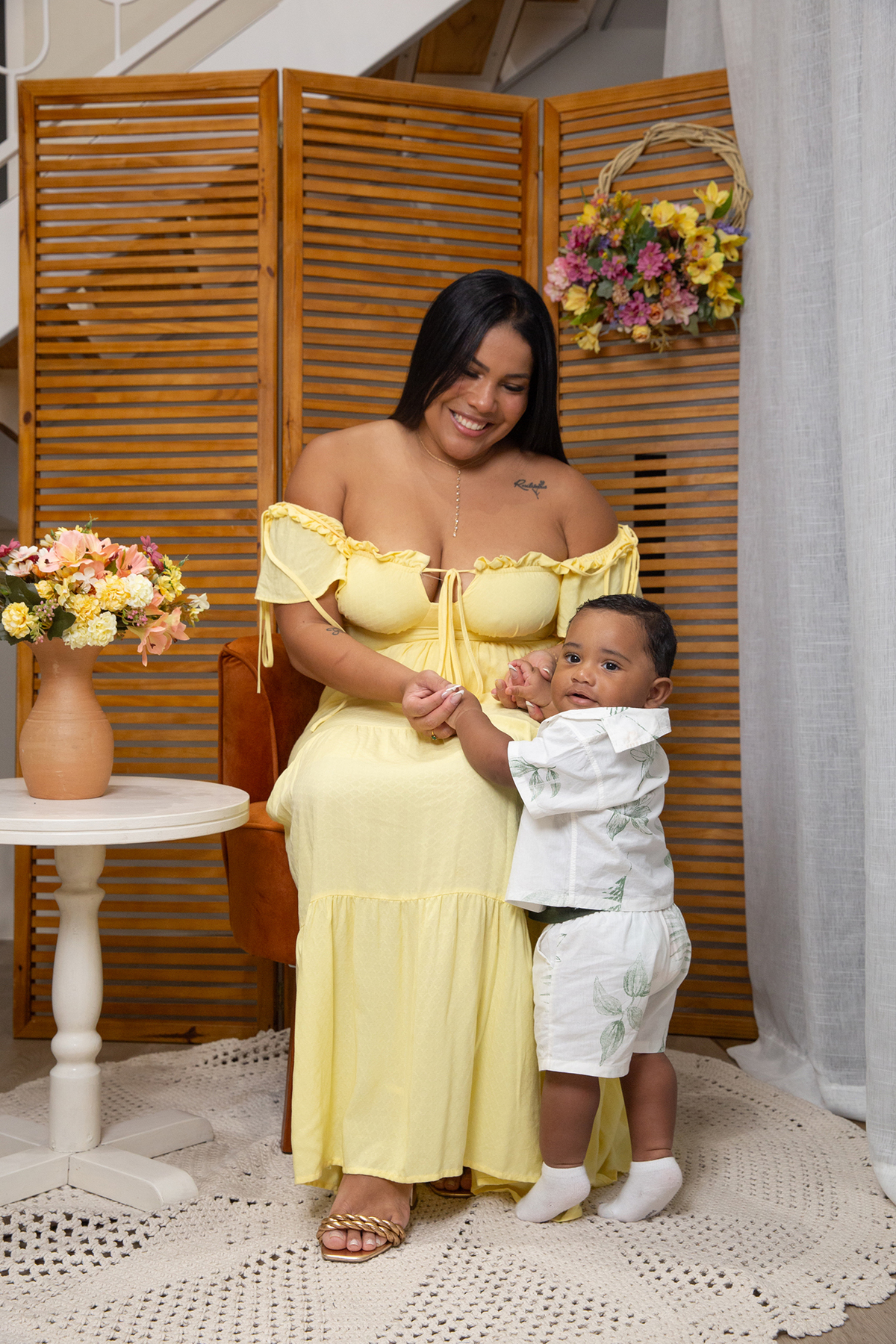 mãe e filho posando para câmera, no cenário de dia das mães Flores, os dois sorrindo