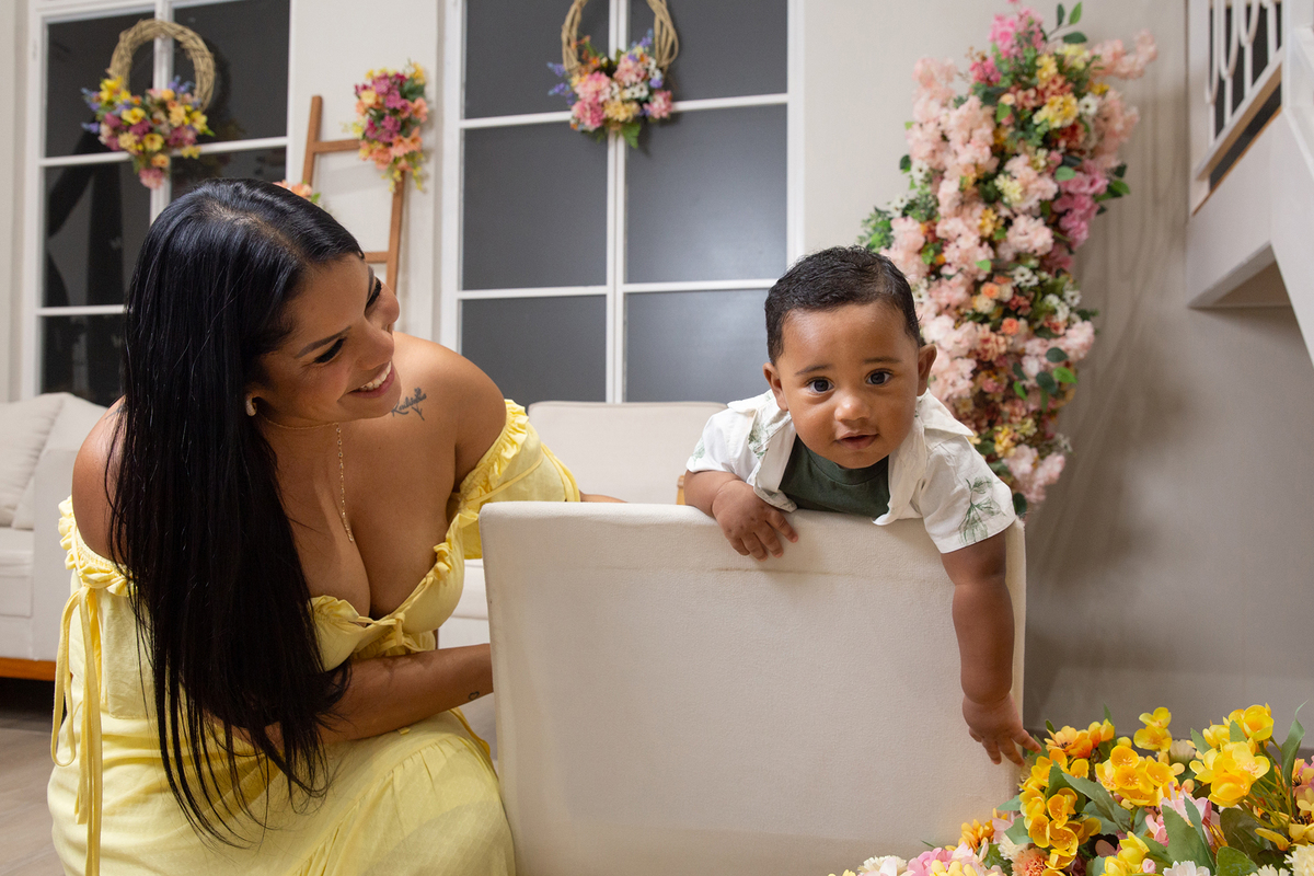 mãe e filho posando para câmera, no cenário de dia das mães Flores, os dois sorrindo