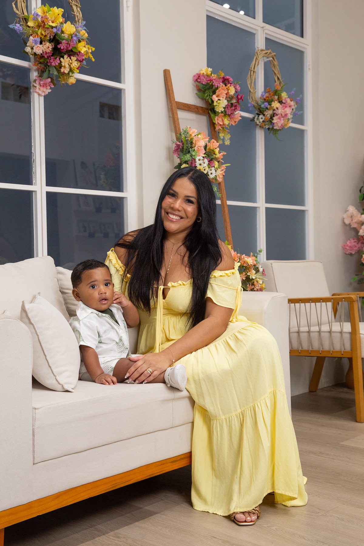 mãe e filho posando para câmera no cenário de dia das mães Flores, os dois sorrindo