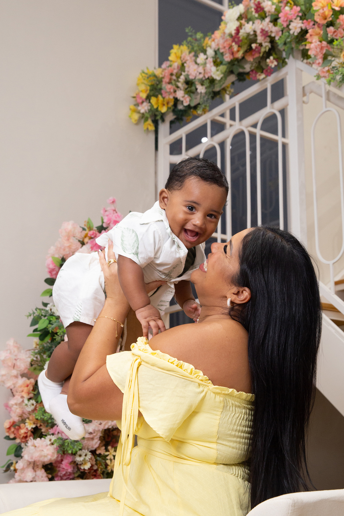 mãe e filho interagindo, brincando no cenário de dia das mães Flores, os dois sorrindo