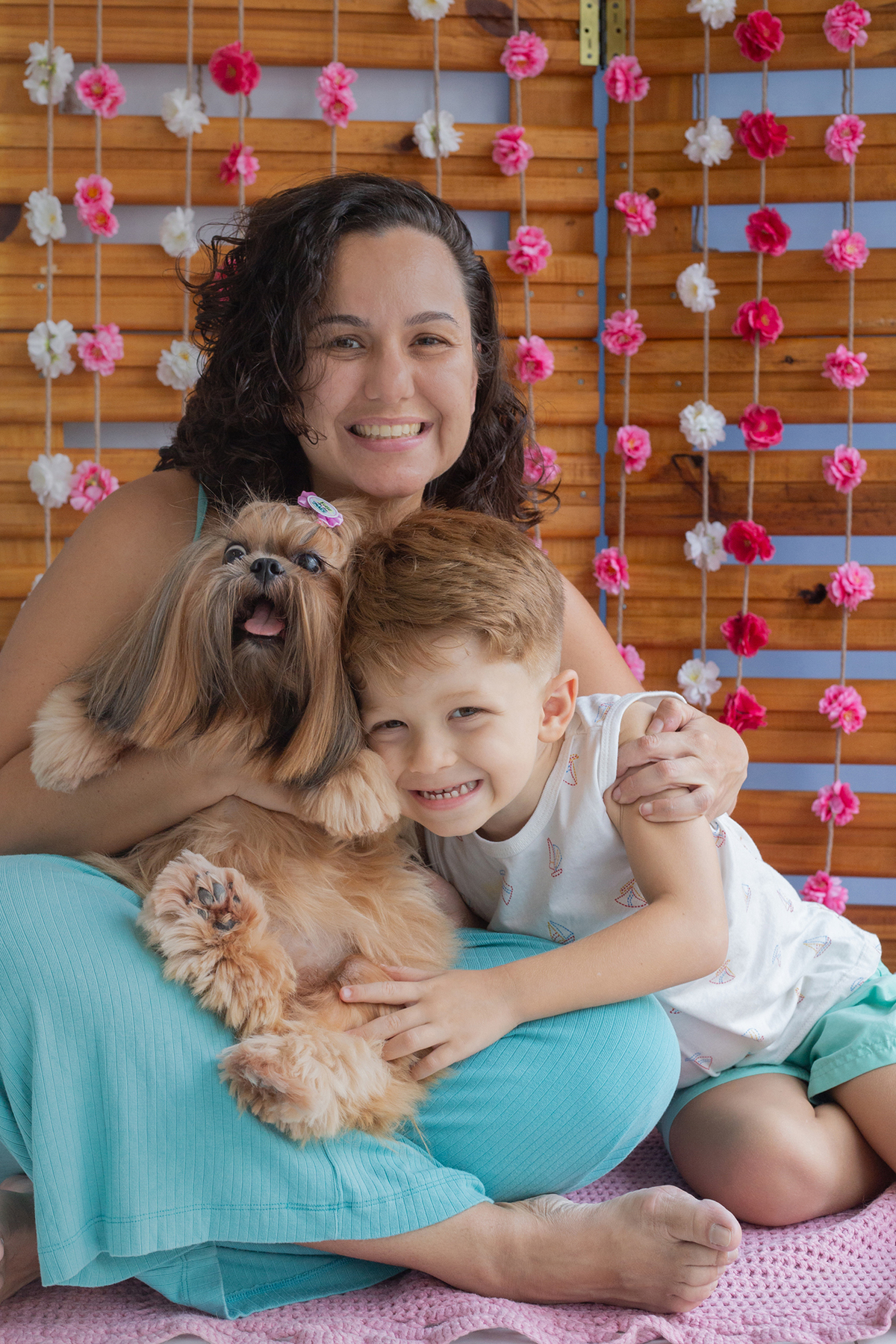 Shih-tzu interagindo no cenário, junto com sua mãe e irmão humanas