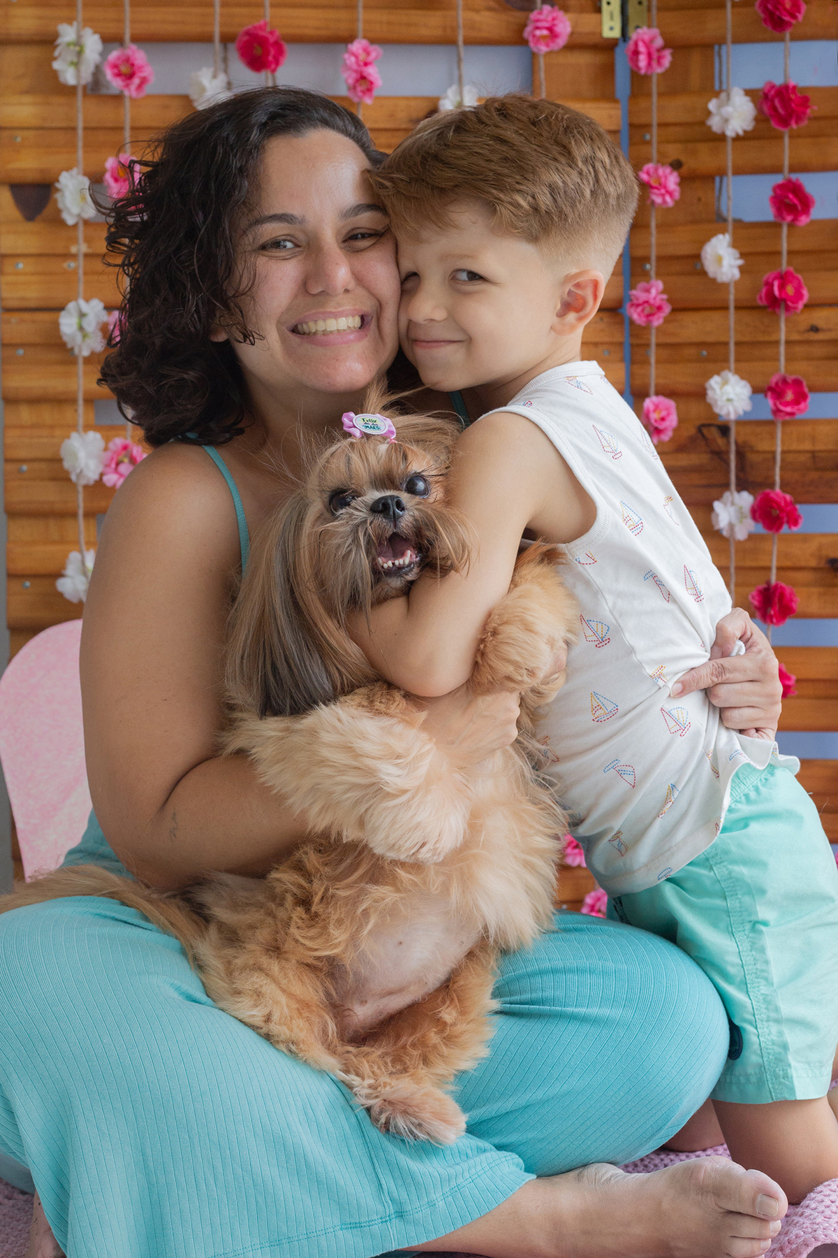 Shih-tzu interagindo no cenário, junto com sua mãe e irmão humanas