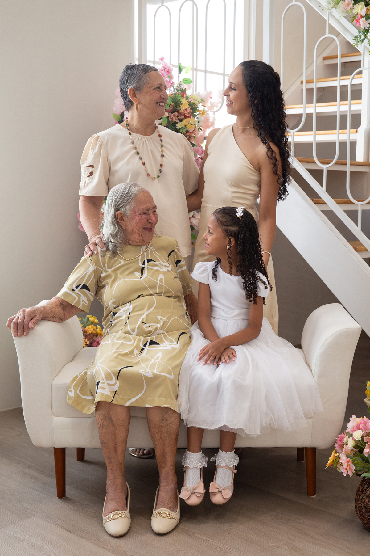 Bisavó, avó, mãe e filha, posam as quatro para foto, no cenário de dia das mães Flores 