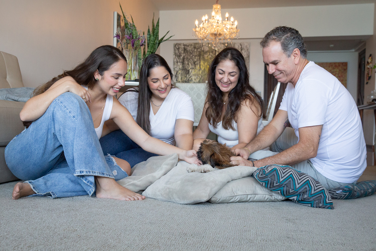 Momento espontâneo durante o ensaio lifestyle em casa, registrando a chegada do pequeno Barto e a conexão da família com seu novo integrante. Mãe, Pai e irmãs