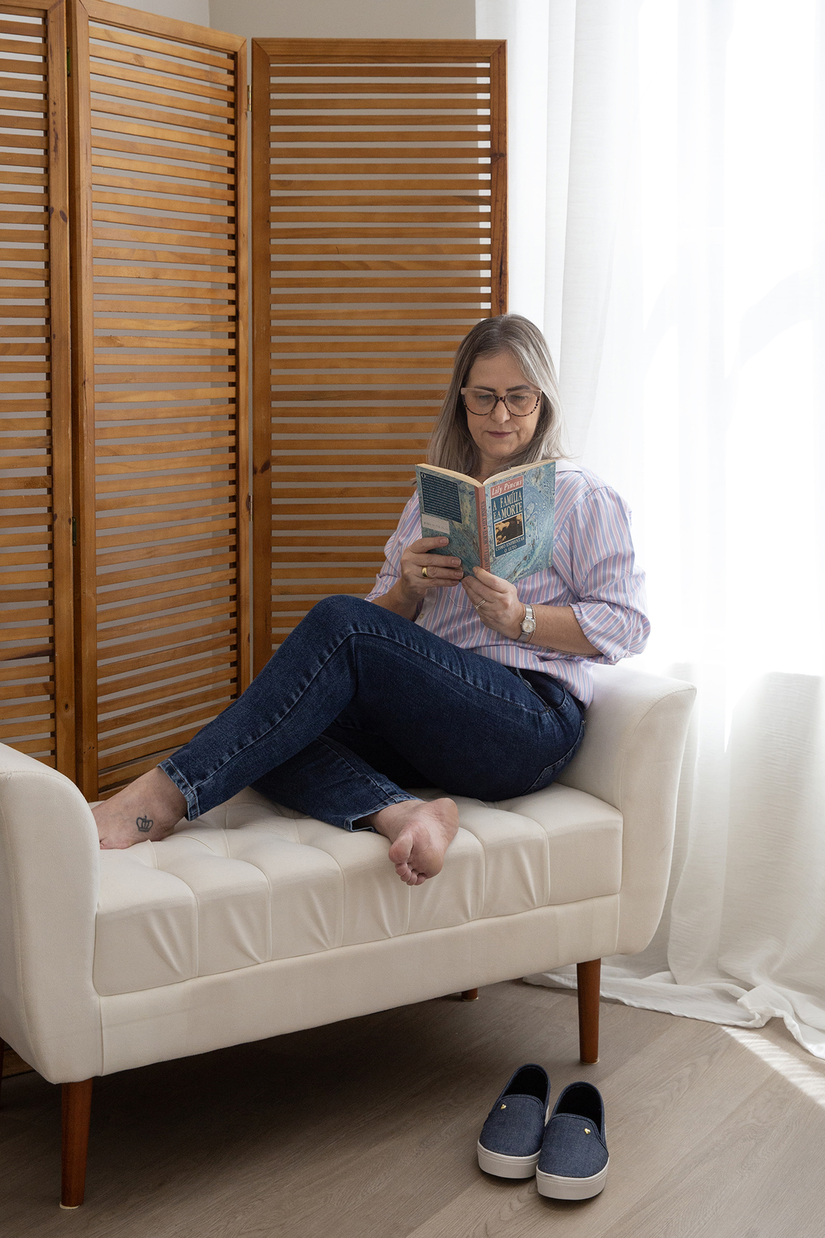 Psicóloga Maristela lendo um livro em ambiente iluminado e confortável