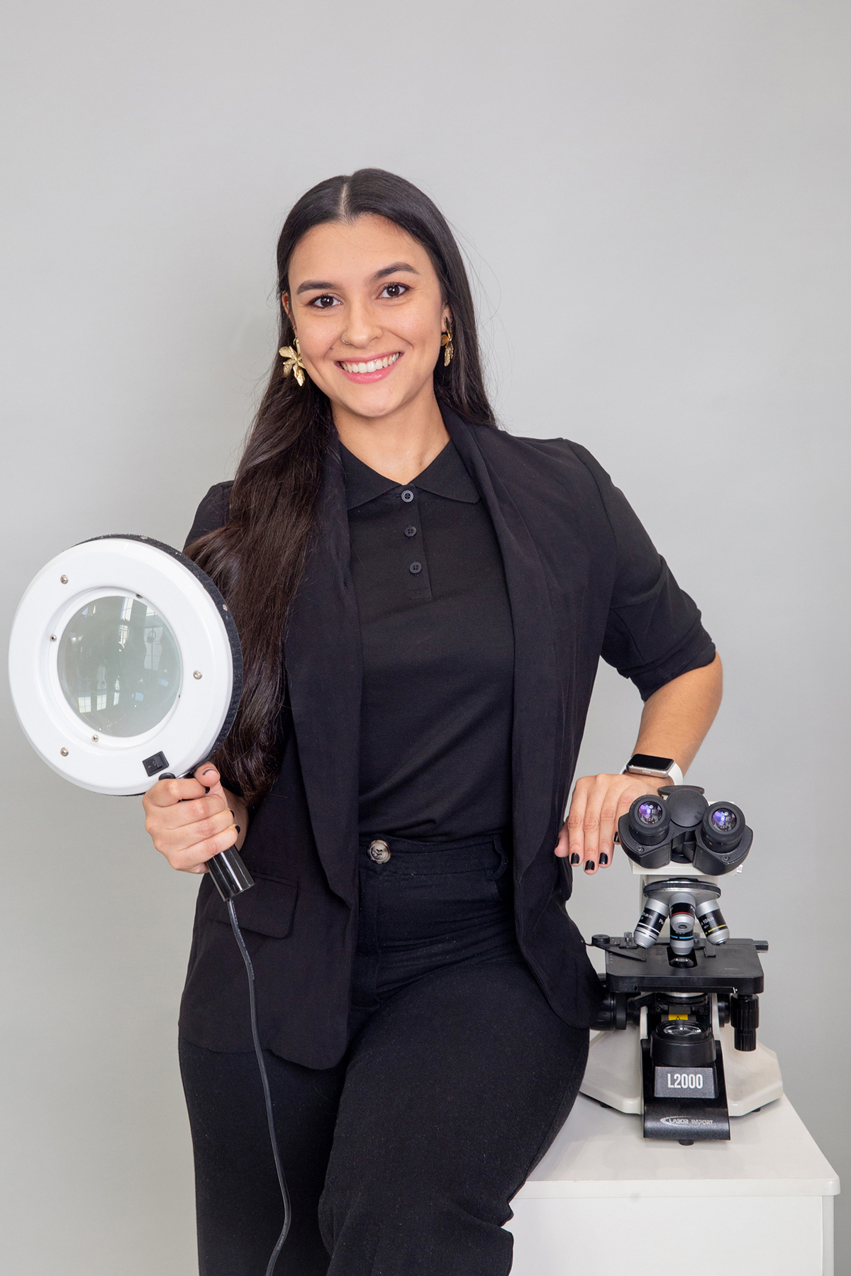 Profissional da equipe veterinária em retrato corporativo com equipamentos de trabalho.