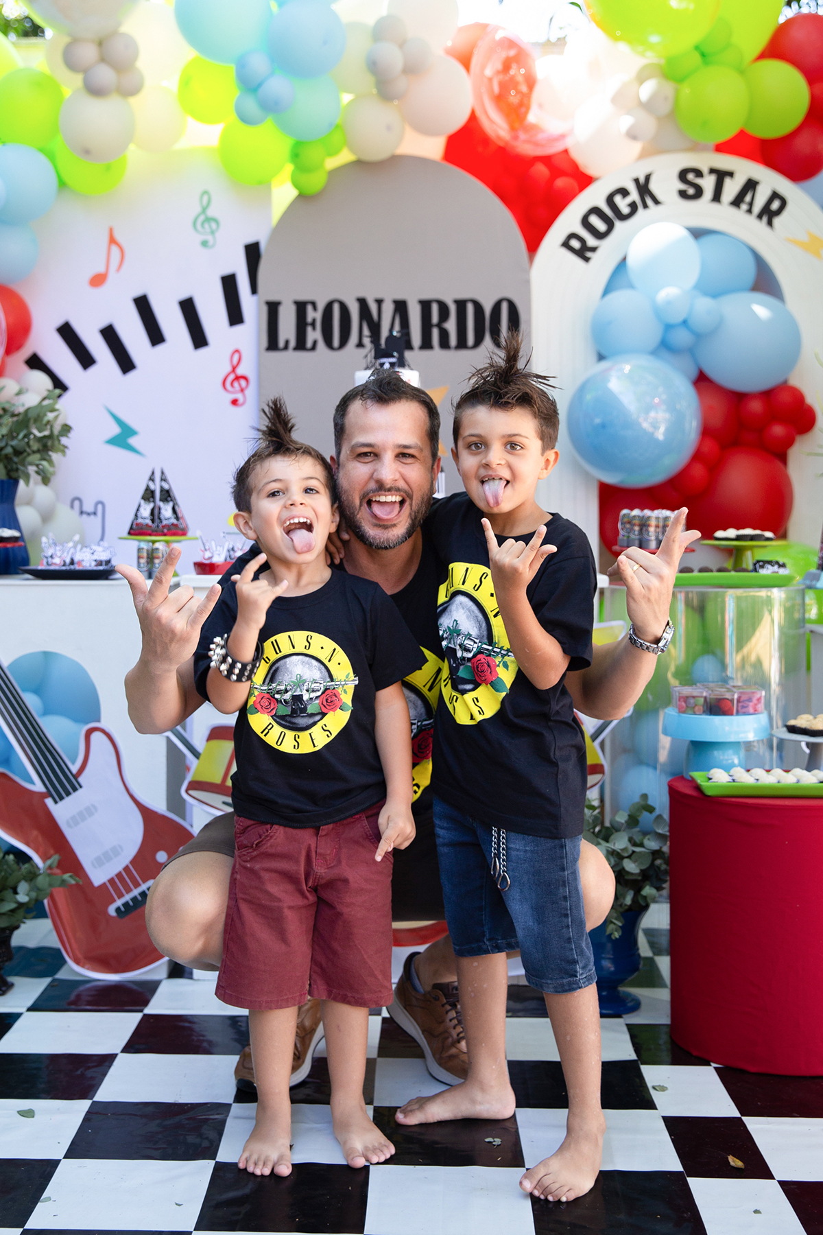 Registro da família reunida em frente à decoração personalizada.