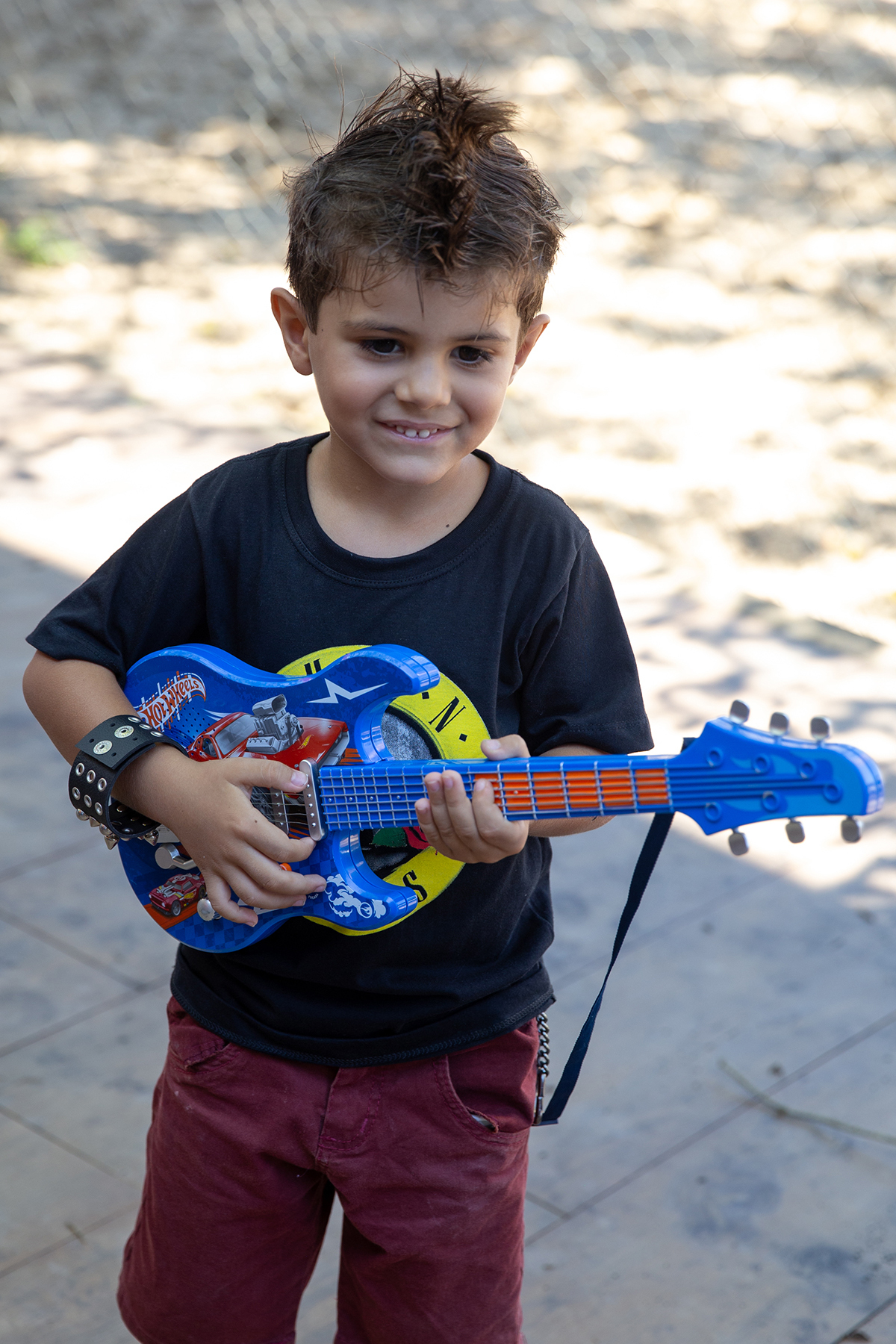 Léo brincando com guitarra de brinquedo no tema rock.