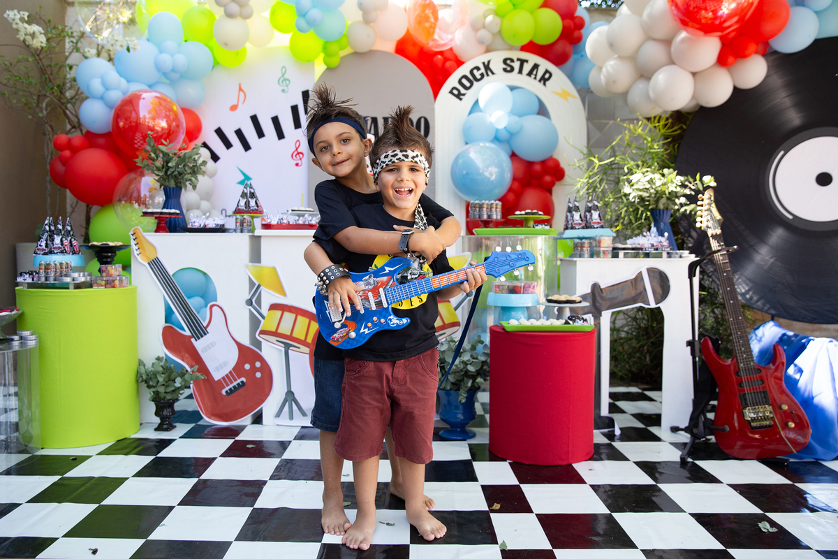 Léo sorrindo ao lado da decoração personalizada de aniversário.