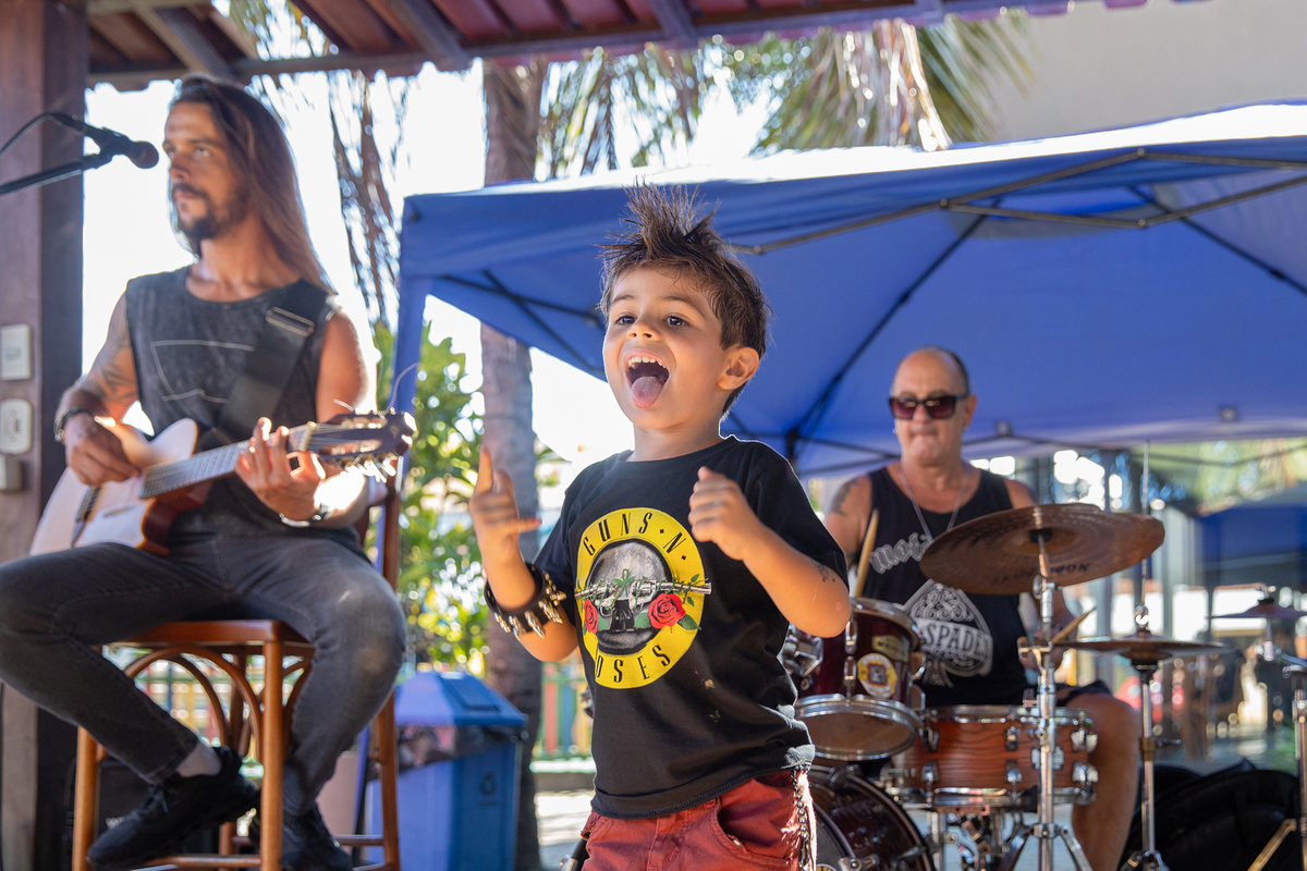 Família acompanhando a apresentação musical da festa infantil.