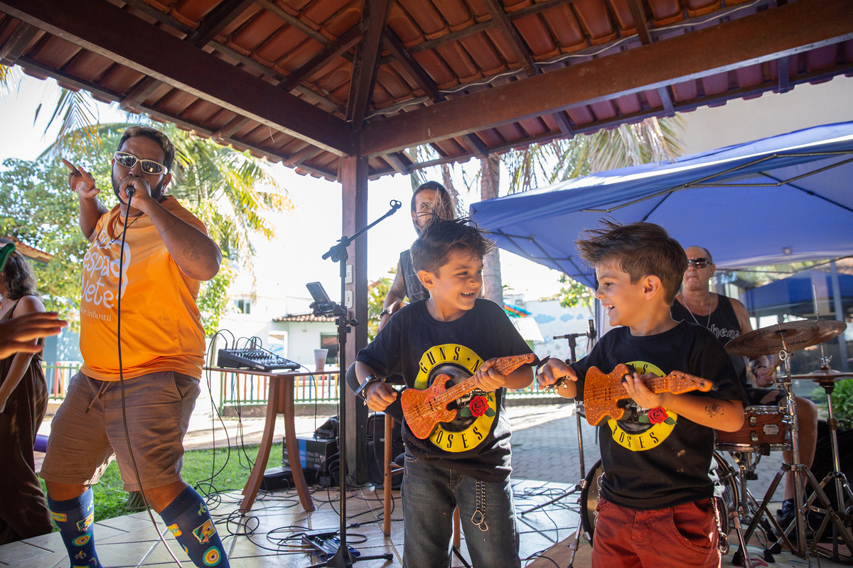 Léo tocando guitarra de brinquedo durante a festa
