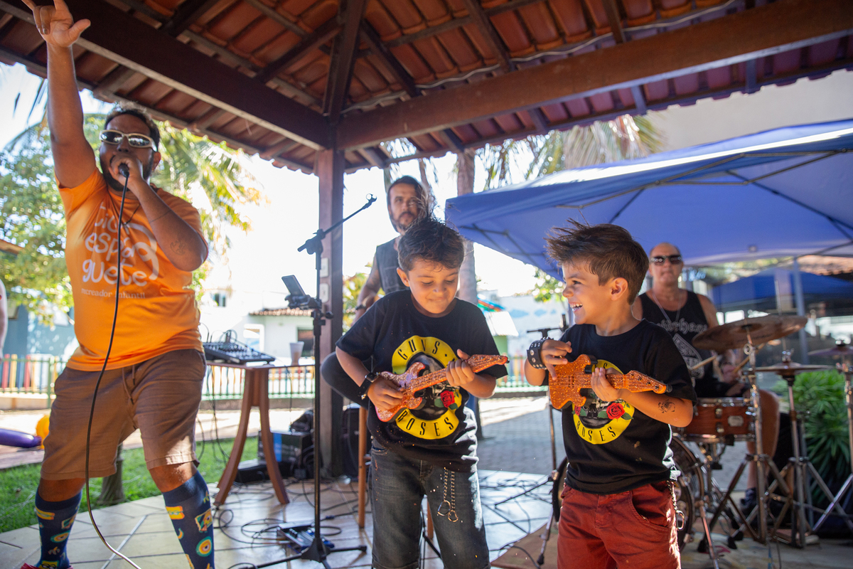 Crianças interagindo com a banda na festa tema rock.