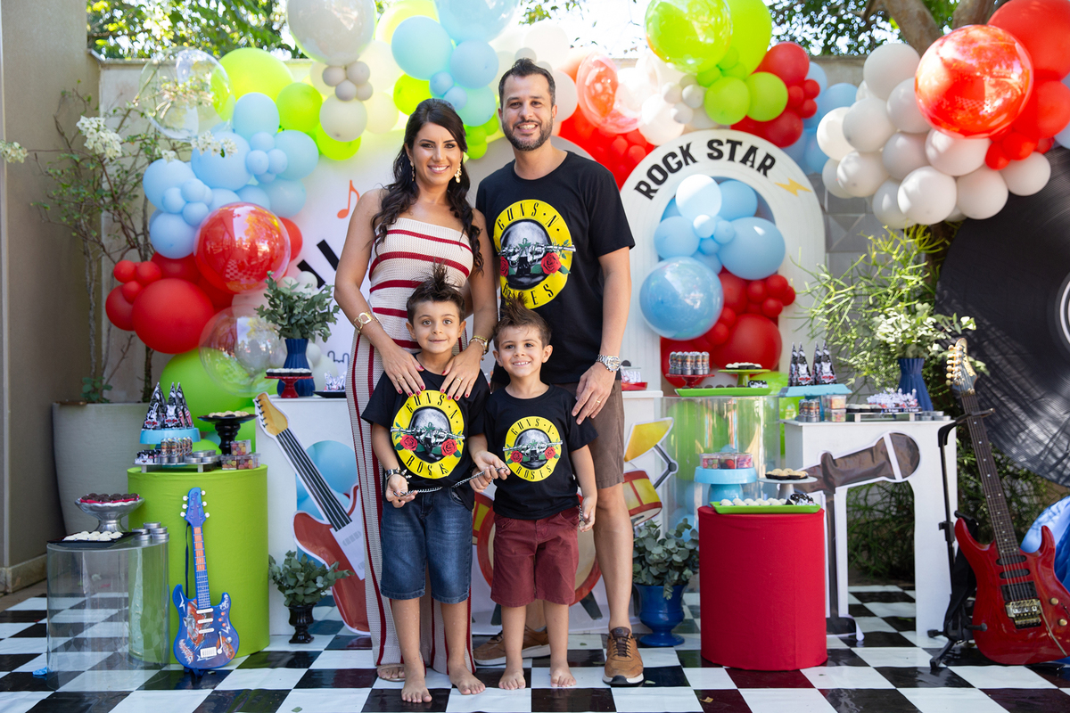 Pais, irmão e aniversariante durante ensaio em frente à decoração da festa.